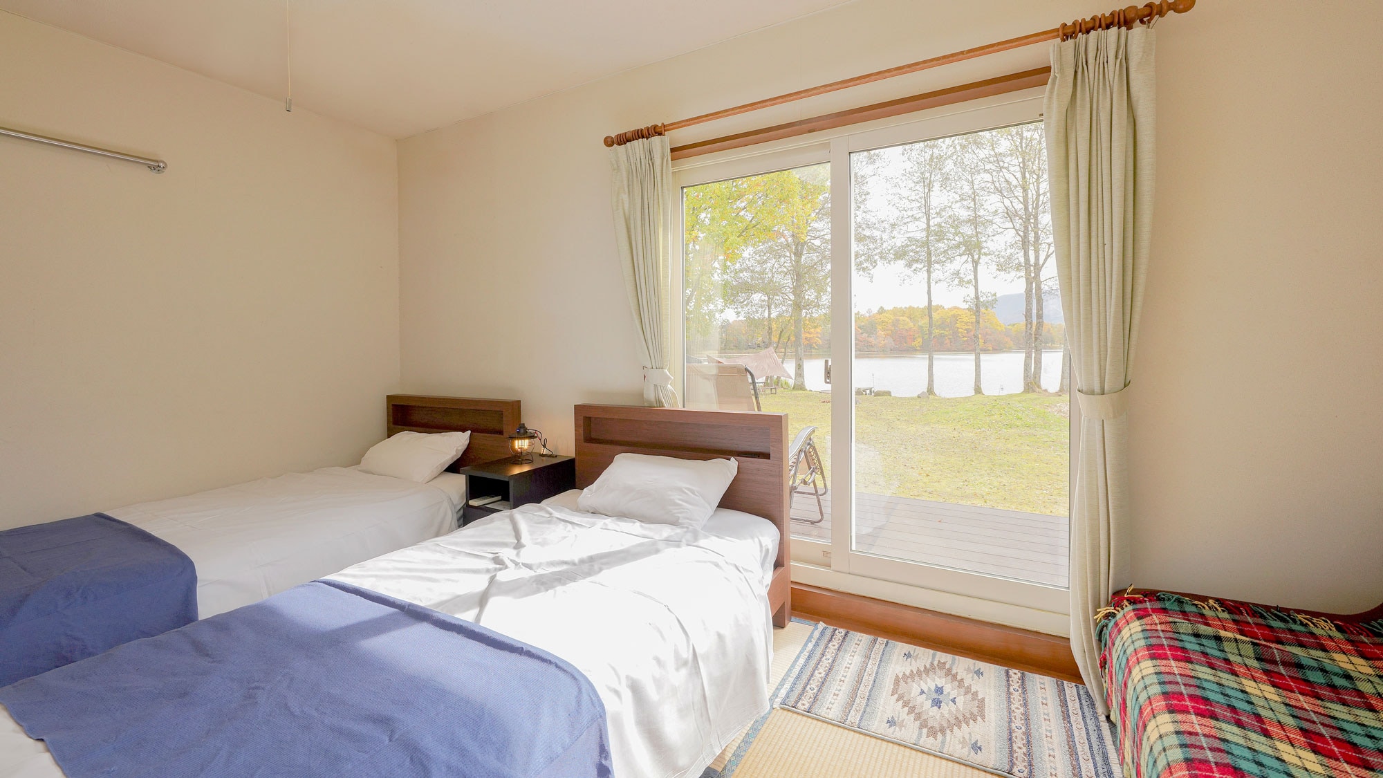 [Lodge] Twin (example). This room has a wooden deck and can be accessed directly from the garden.