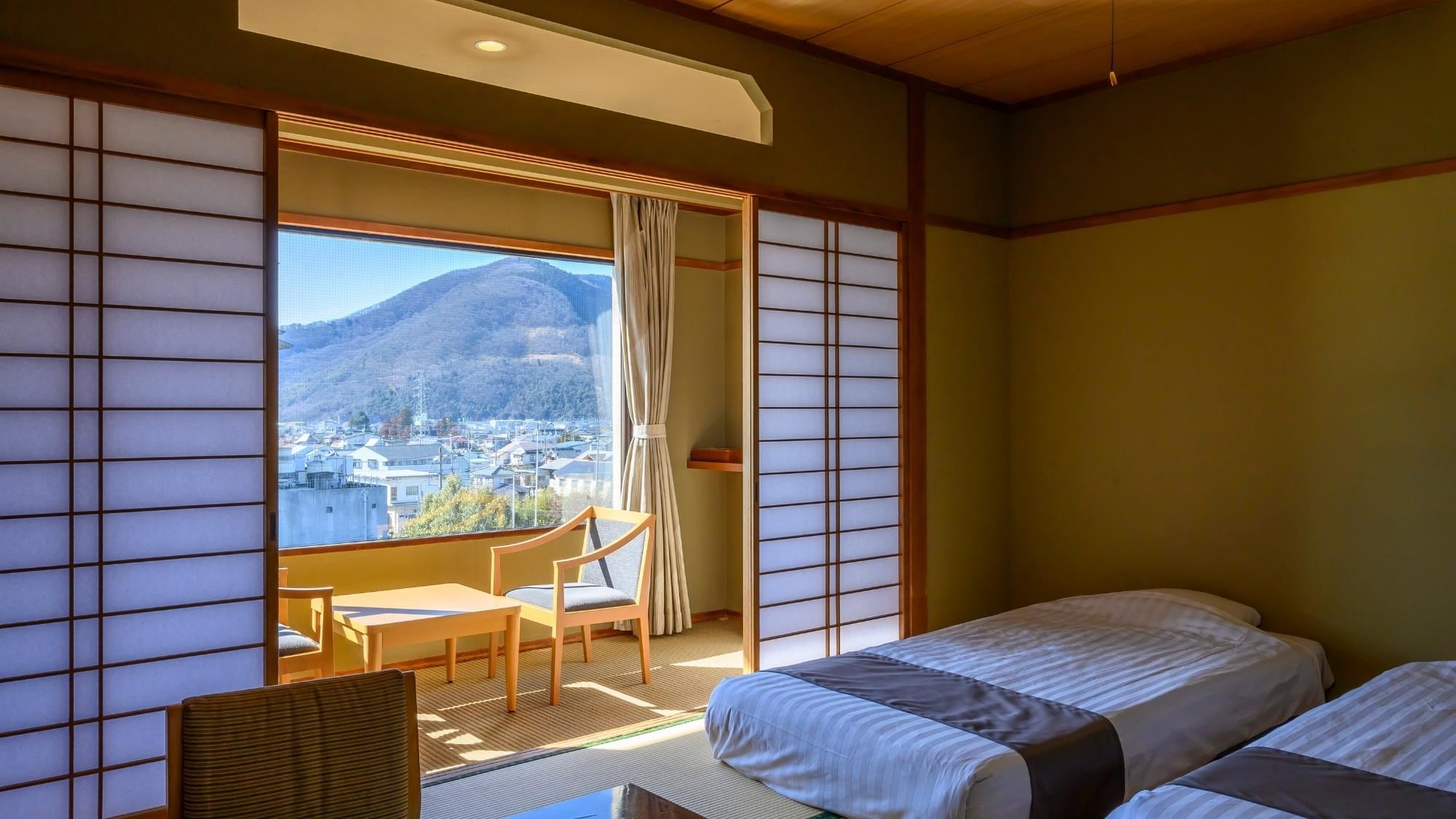 [Japanese-style room with 10 tatami mats and low-type bed] Enjoy a relaxing time with the mountain view from the window.
