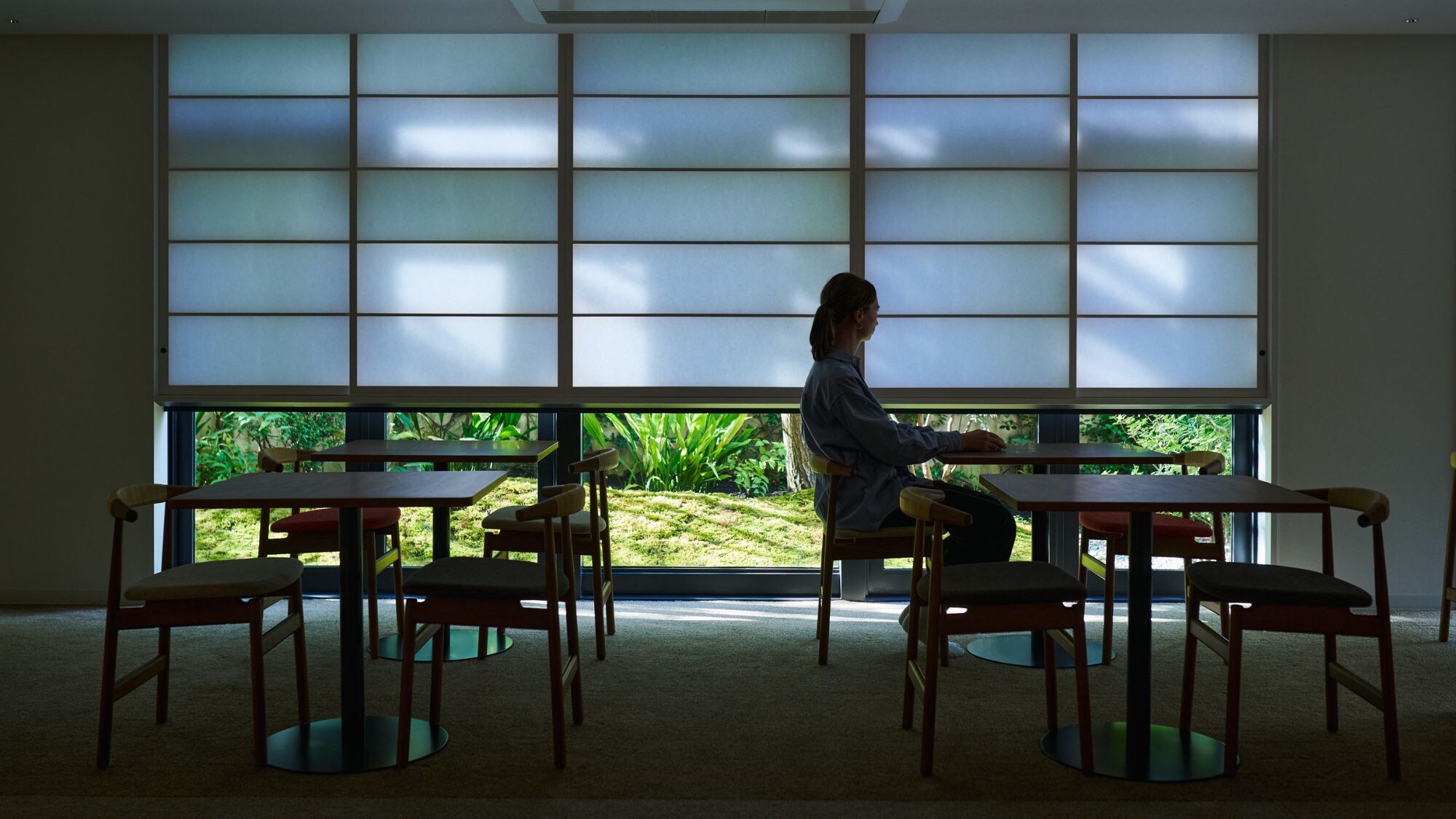 ห้องนั่งเล่นได้รับแสงอ่อนๆ ผ่านม่านโชจิ