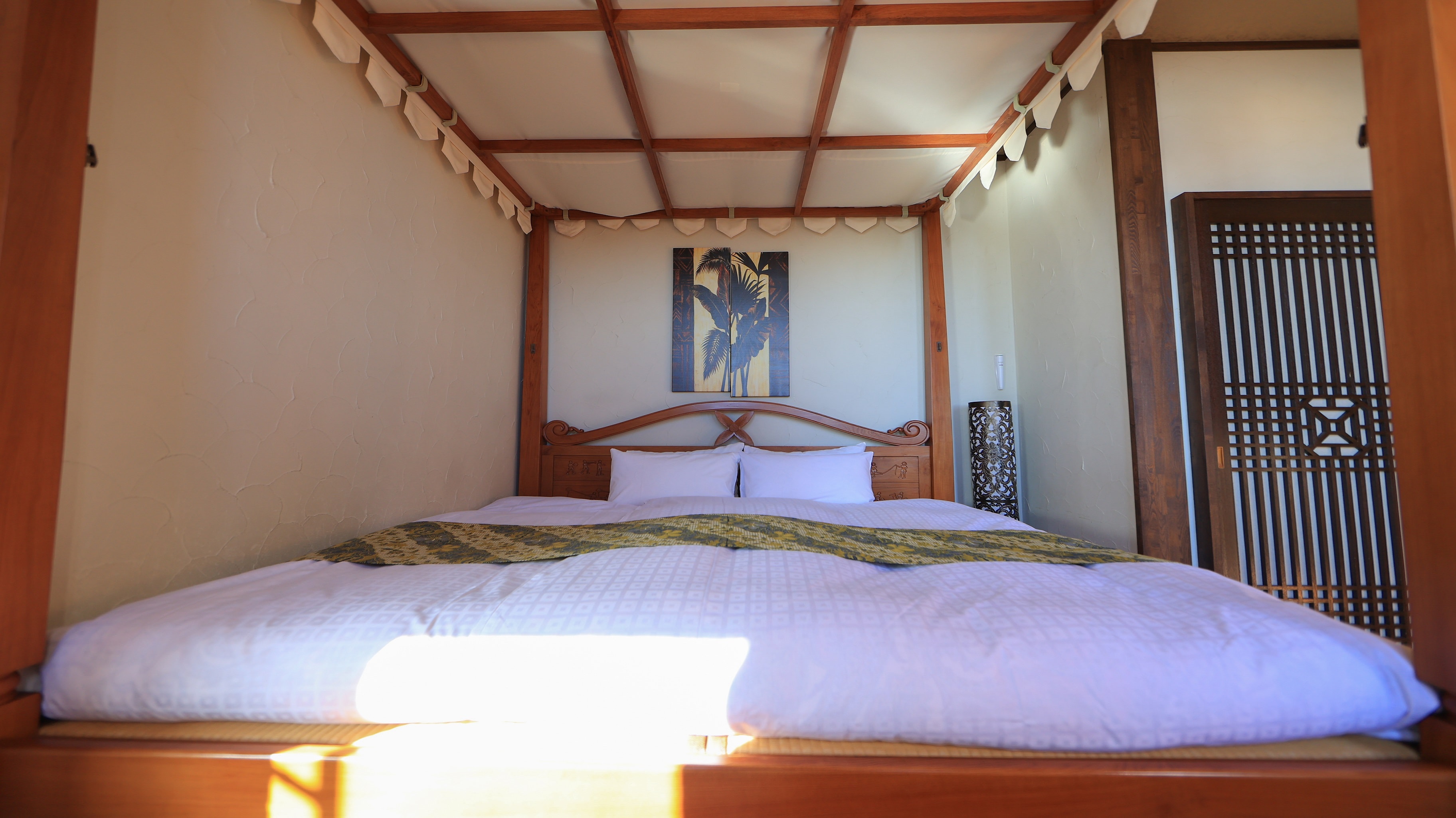 Enjoy a peaceful sleep in a Bali room with a natural hot spring overlooking the ocean and a canopy king-size bed surrounded by a resort atmosphere.