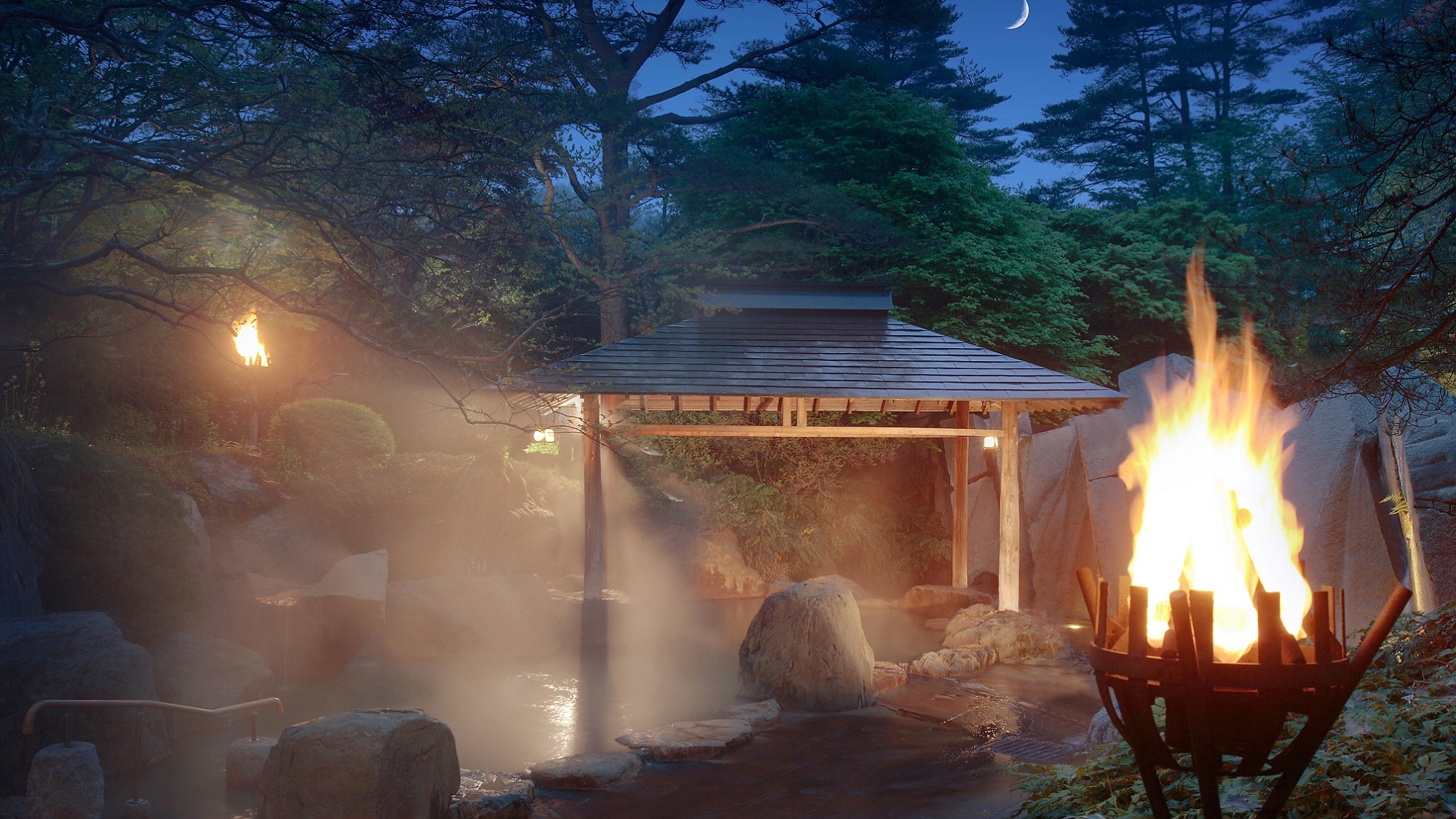 The open-air bath "Kagari no Yu" is lit from dusk.