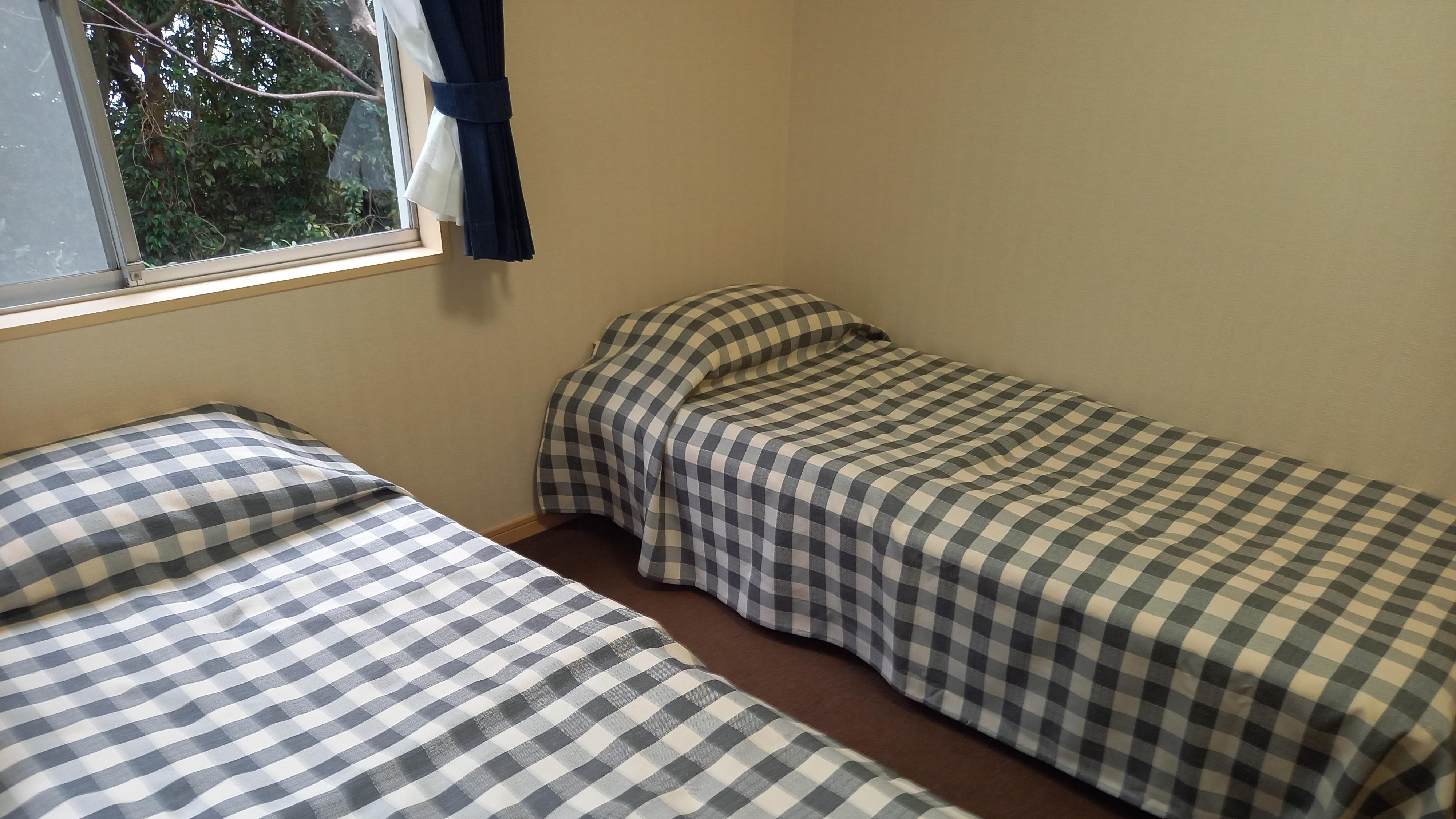* [Twin Room] A twin room with a large window that gives it a bright impression.