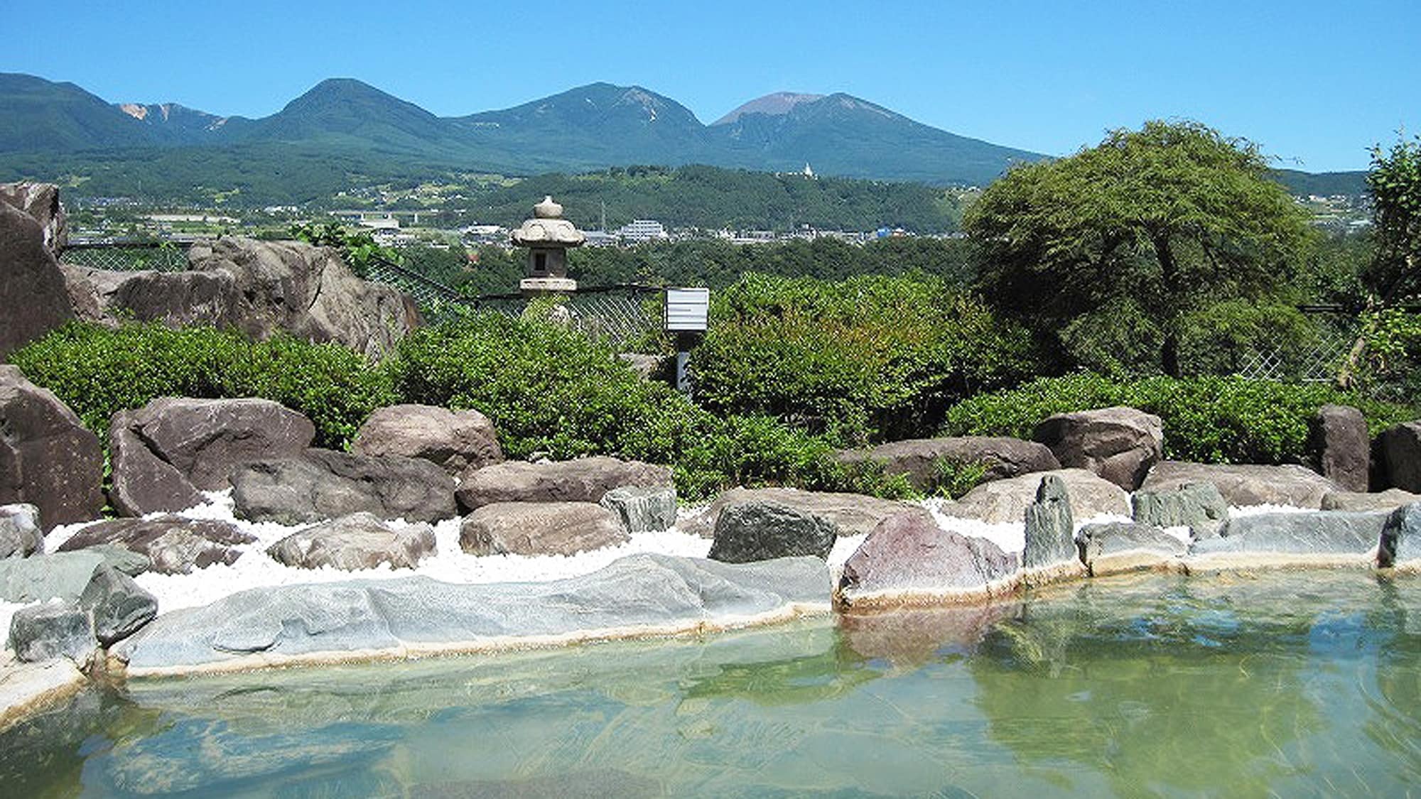 *[Open-air bath (summer)] The open-air bath is a spacious rock bath with a panoramic view of Mt. Asama and the town of Komoro.