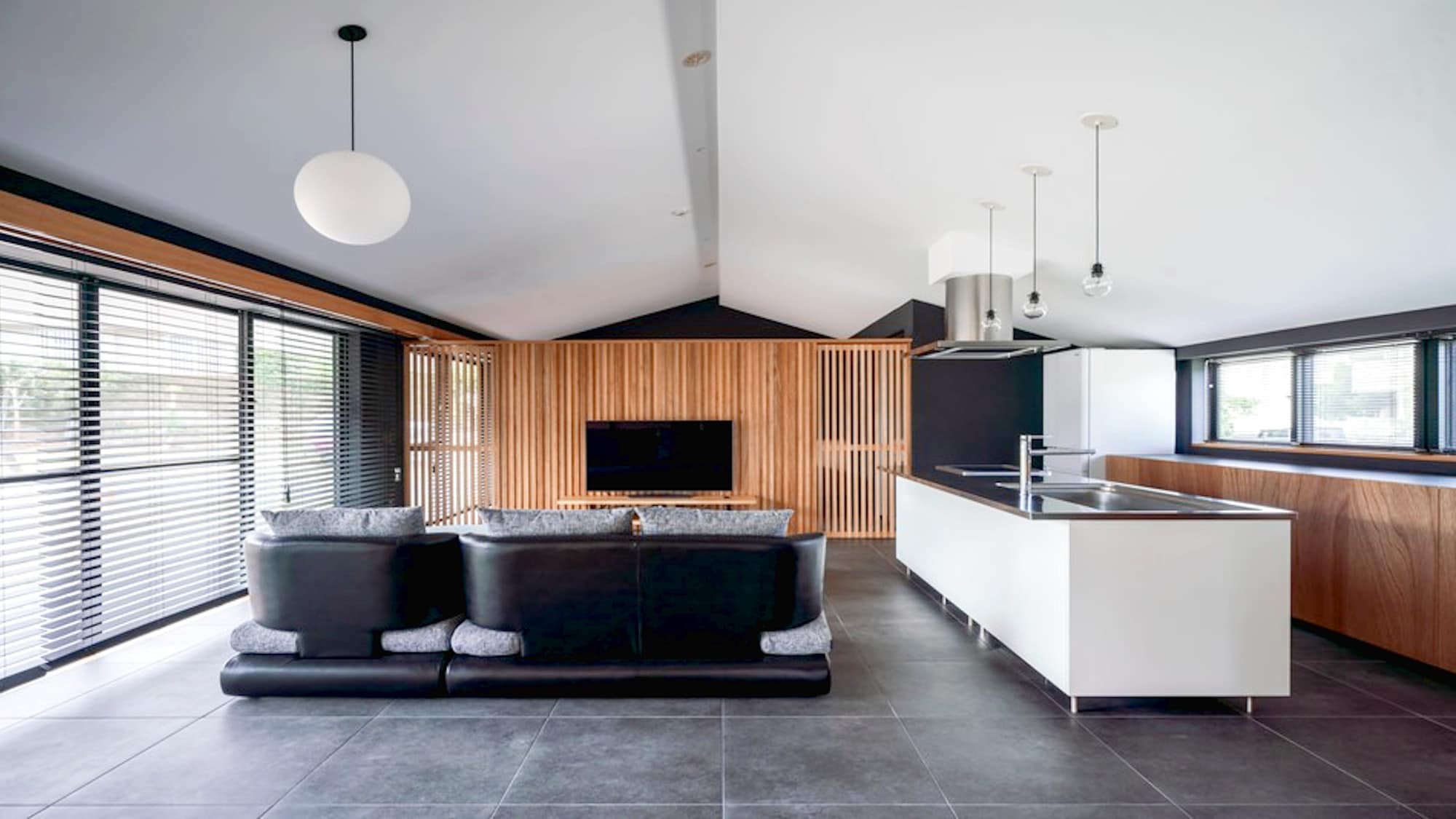・The living/dining/kitchen area is designed to resemble a resort hotel. The floor is tiled and the walls are all black.