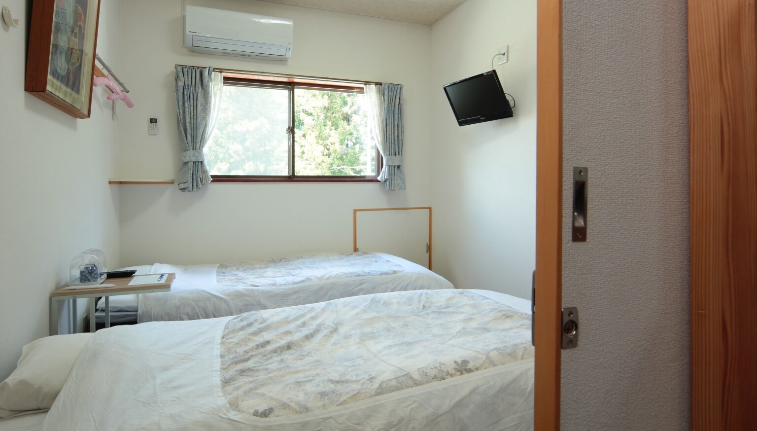 Kamar ini memiliki dua tempat tidur sederhana.