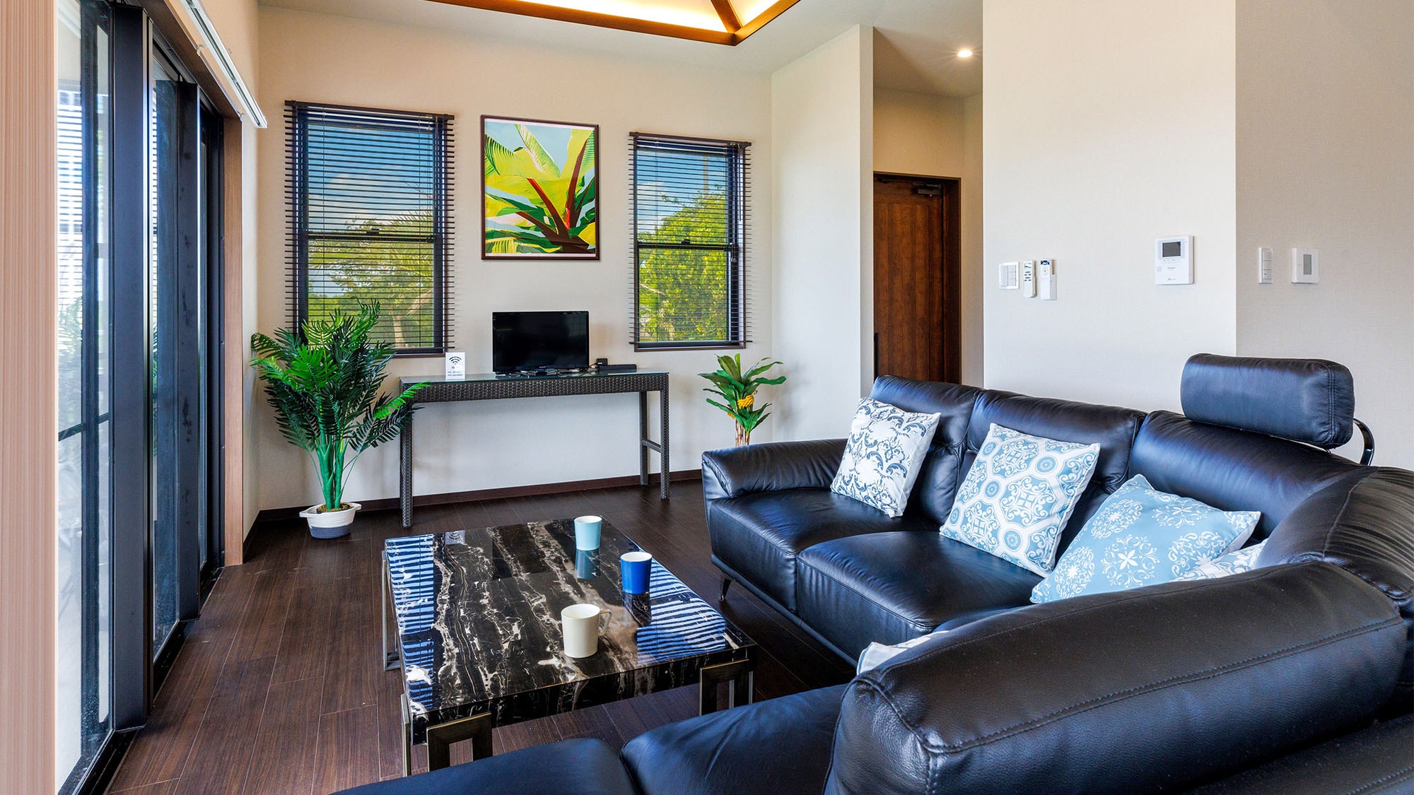 ・Villa 1 living room: equipped with a black leather sofa