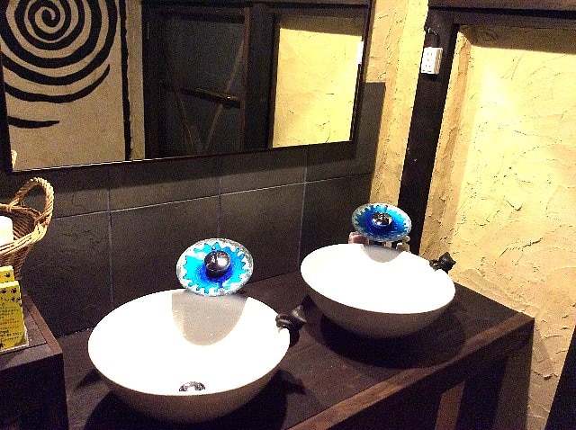 This is a shared washstand with a faucet that resembles the ocean. There is also a large mirror and a hair dryer.