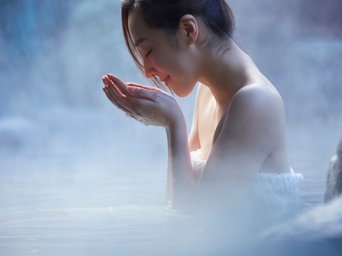 A woman bathing in an open-air bath