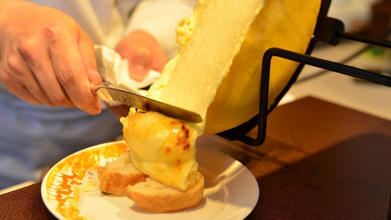 Nikmati keju raclette yang dituangkan dengan murah hati di atas baguette dan sayuran (makan malam prasmanan)