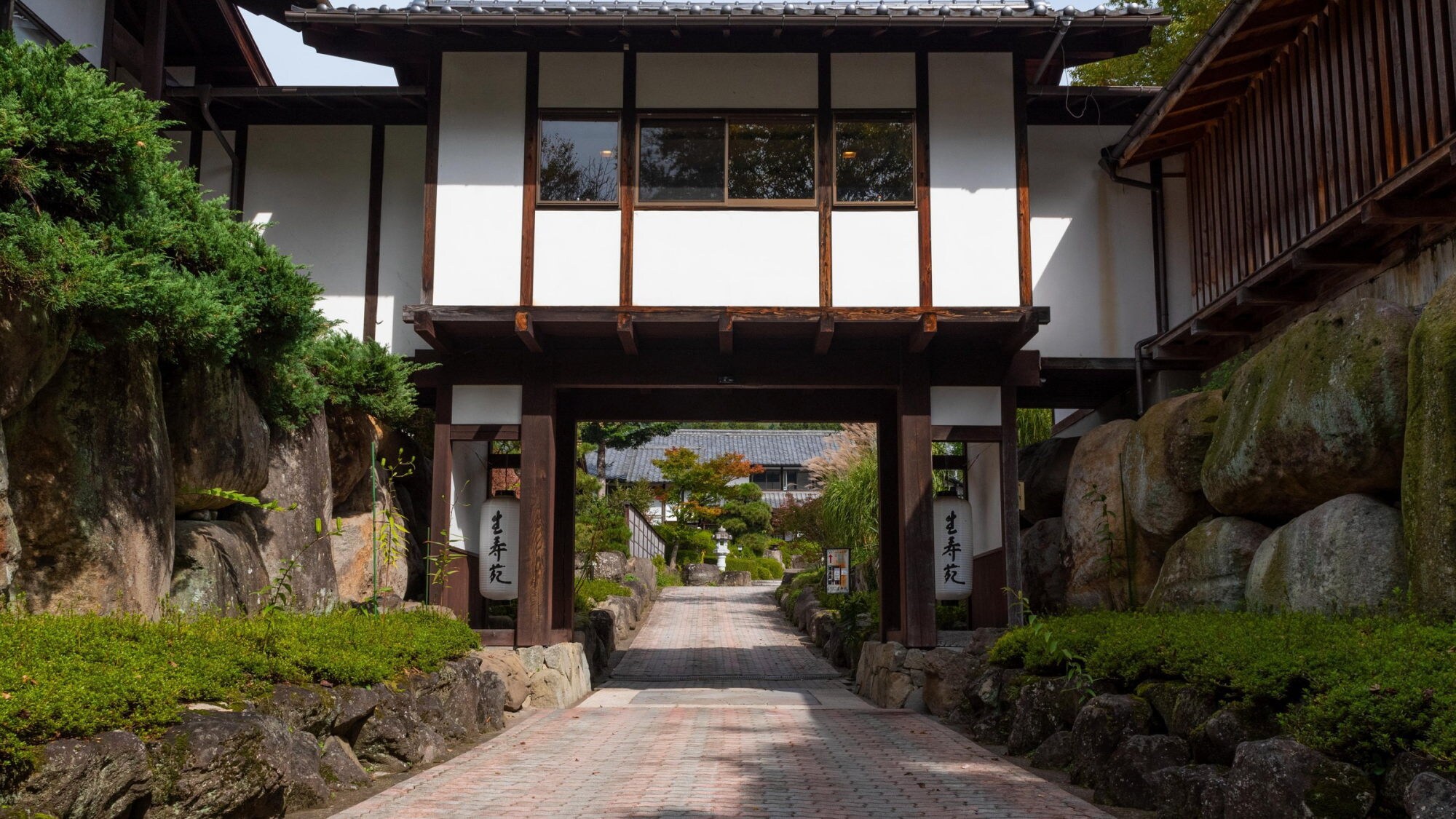 [Daimon] Near the entrance to the inn. The bath building is on the right and the guest room building is on the left.