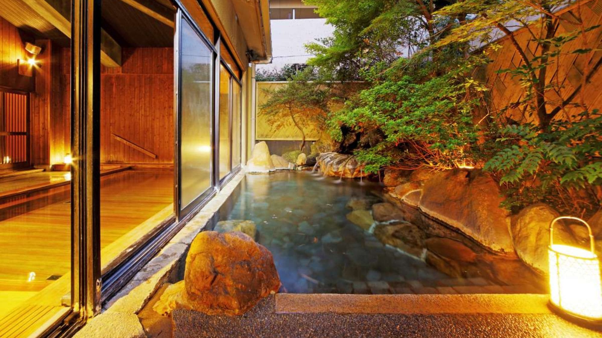 [Kaede no Yu Open-air Bath] A charming atmosphere at night. Watching the hot water flow from the large rocks feels like it will wash away your soul.