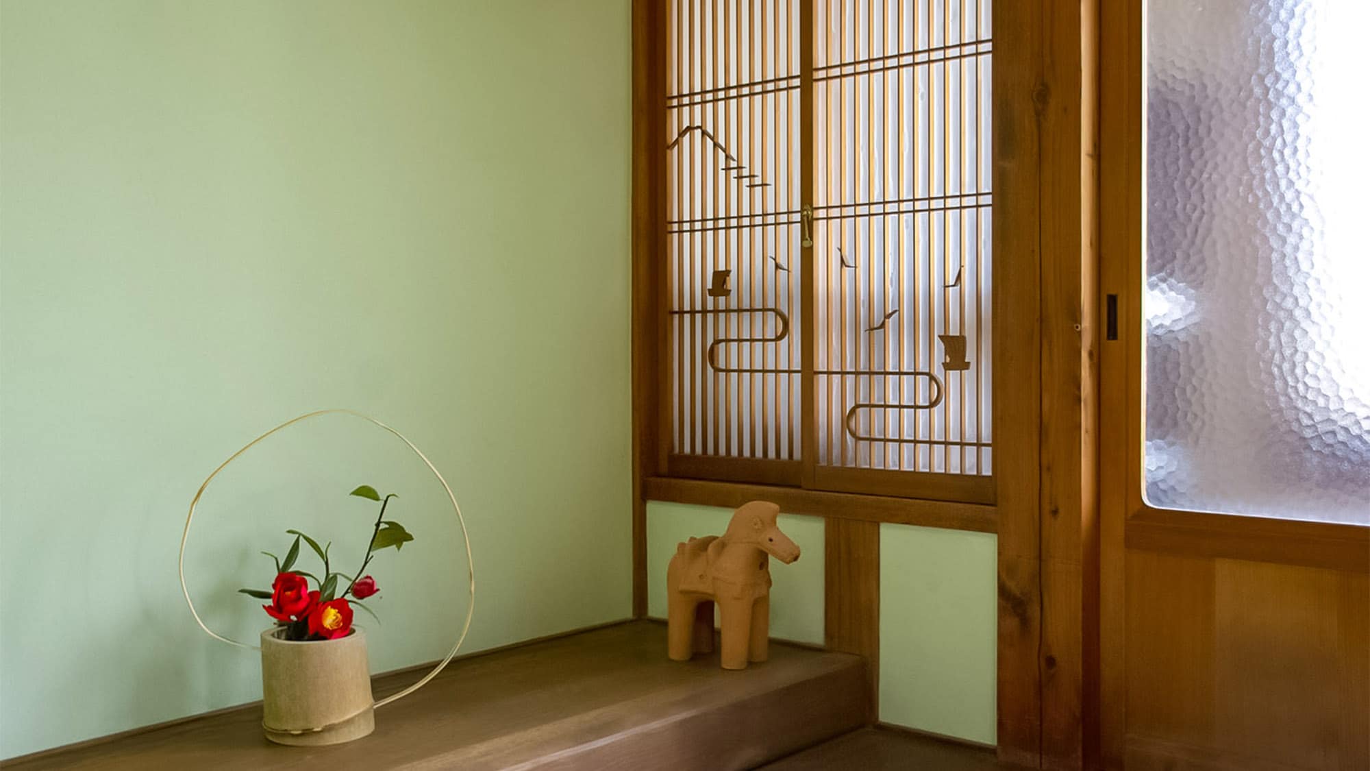 ・<Example of a guest room> A tokonoma alcove with soft, soothing green wallpaper