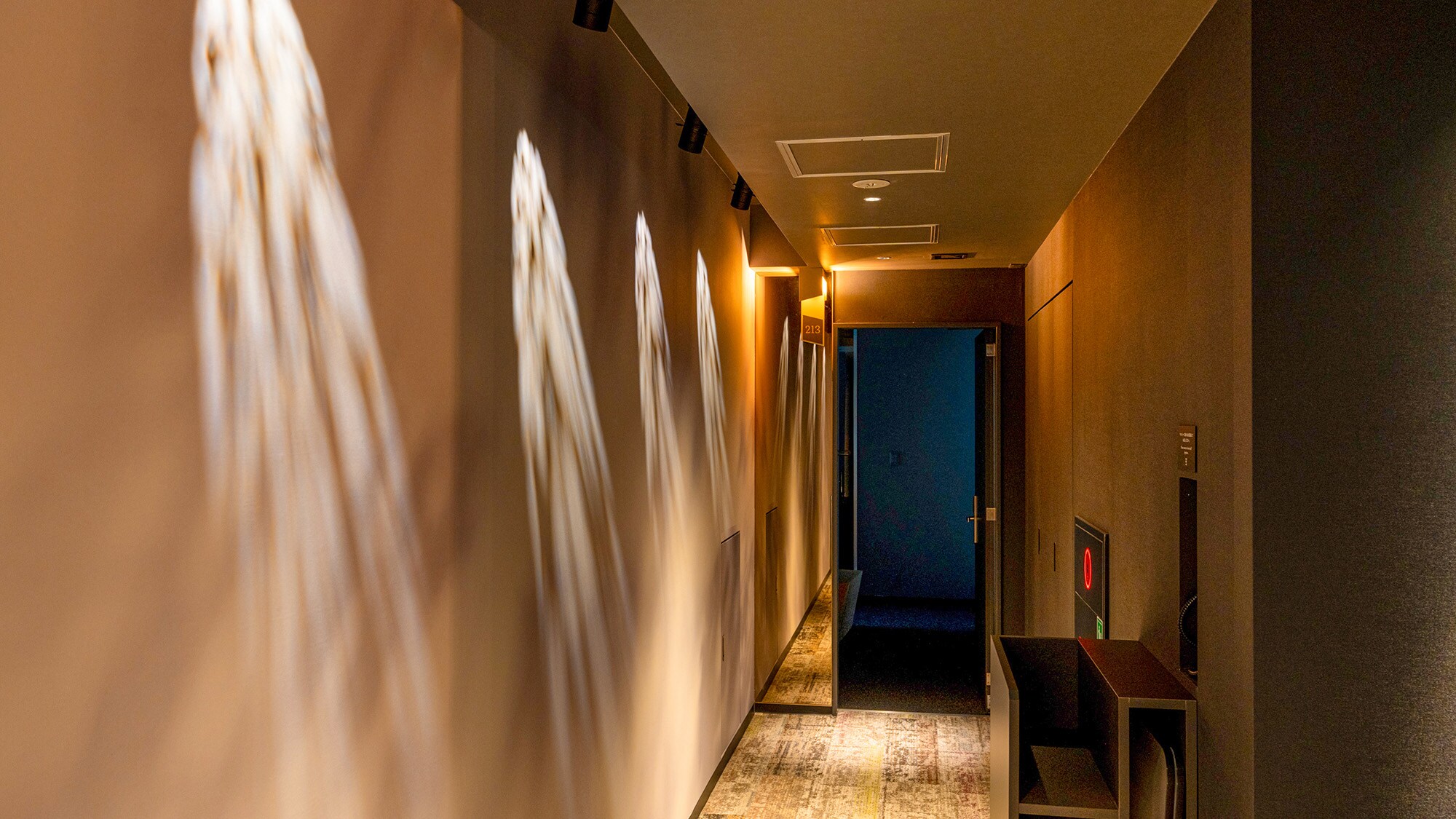 [Interior design (corridors)] The design allows the light to shine on the walls, creating the illusion of hidden paintings.