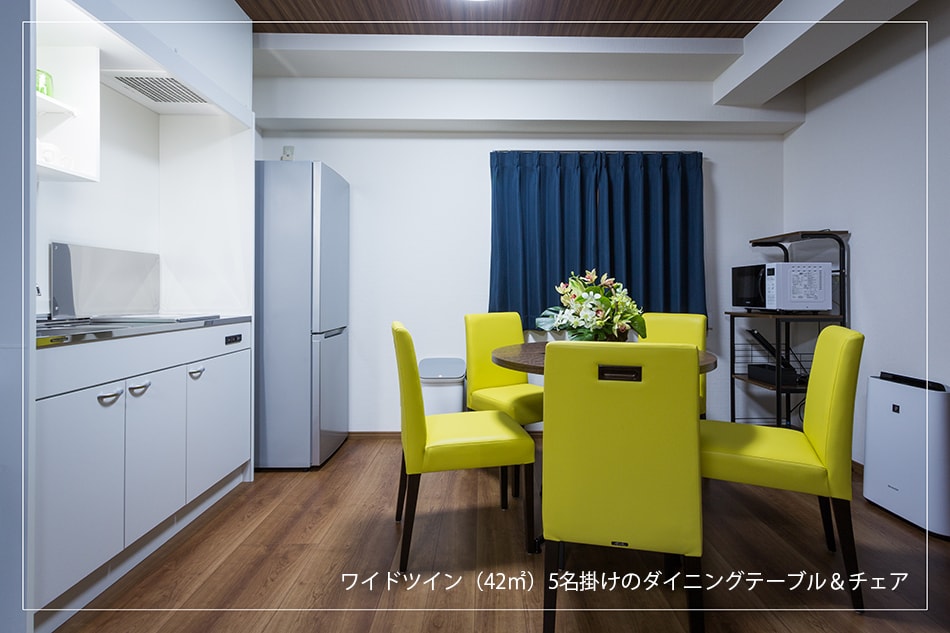 The wide twin (42.0㎡) living room is equipped with a large refrigerator and a dining table for 5 people.