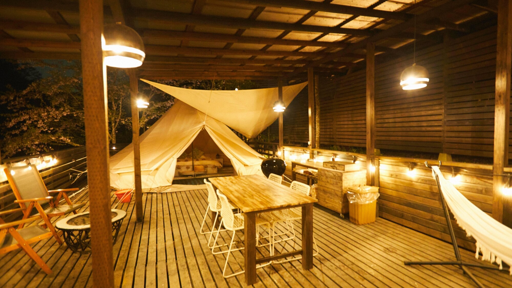*[SITE_D/Deck] Tận hưởng khoảnh khắc sang trọng trên sân thượng được chiếu sáng và bao quanh bởi làn gió đêm.