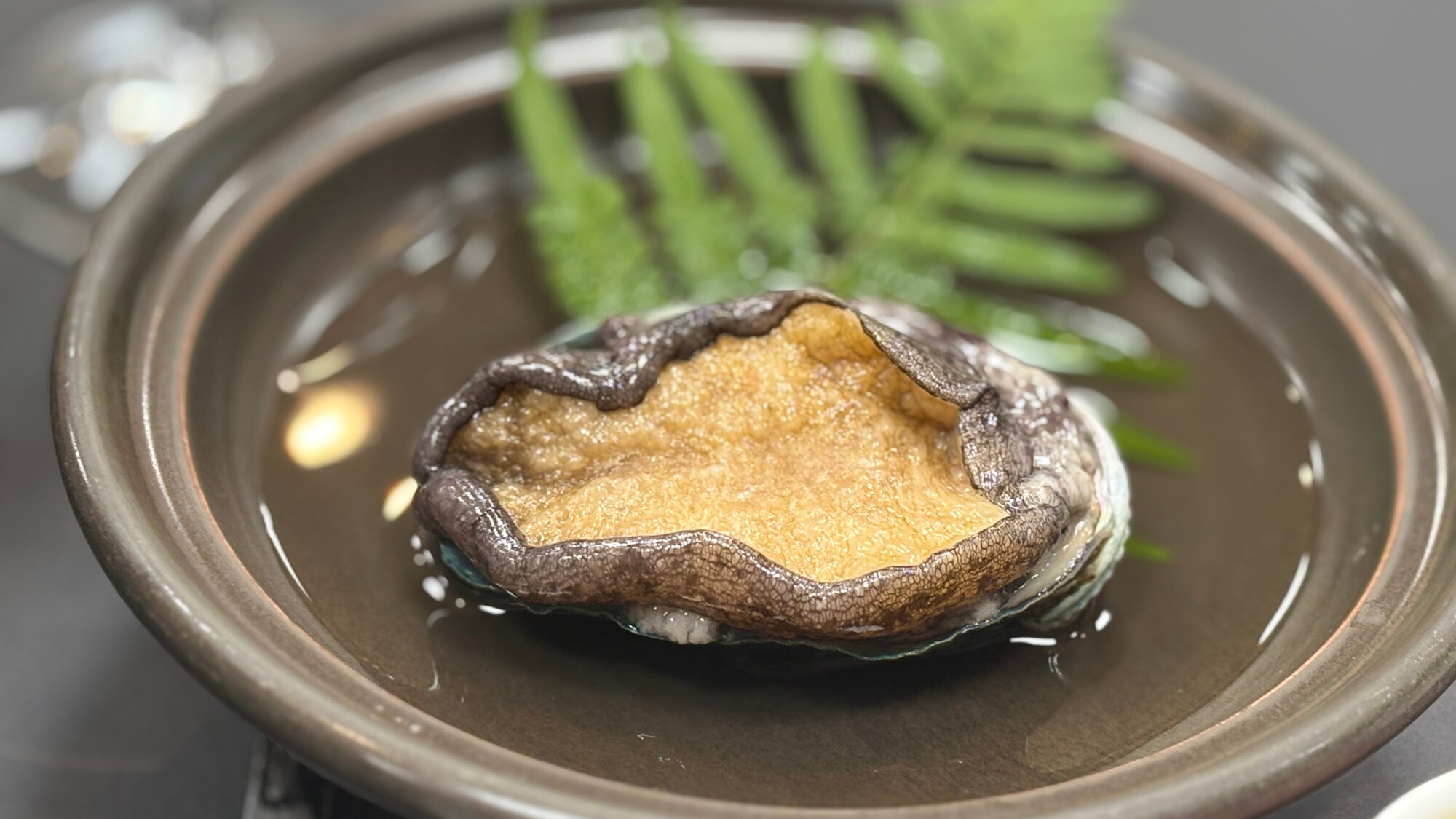 Miyabi Kaiseki | Tenderly cooked abalone grilled on a ceramic plate.