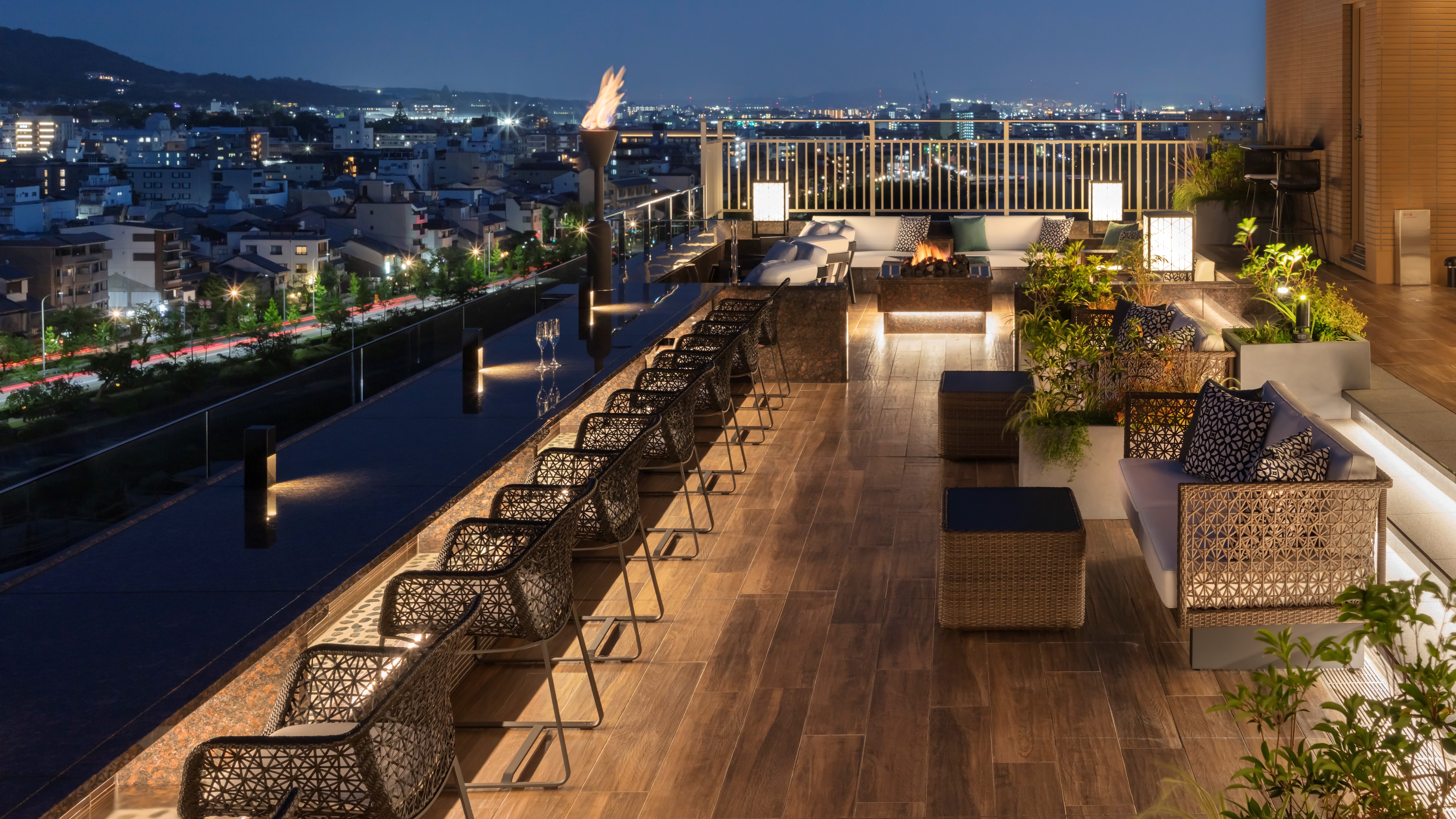 Rooftop lounge "Solaniwa Terrace" Bar time with flickering light of bonfire and night view of Kyoto, drink in hand