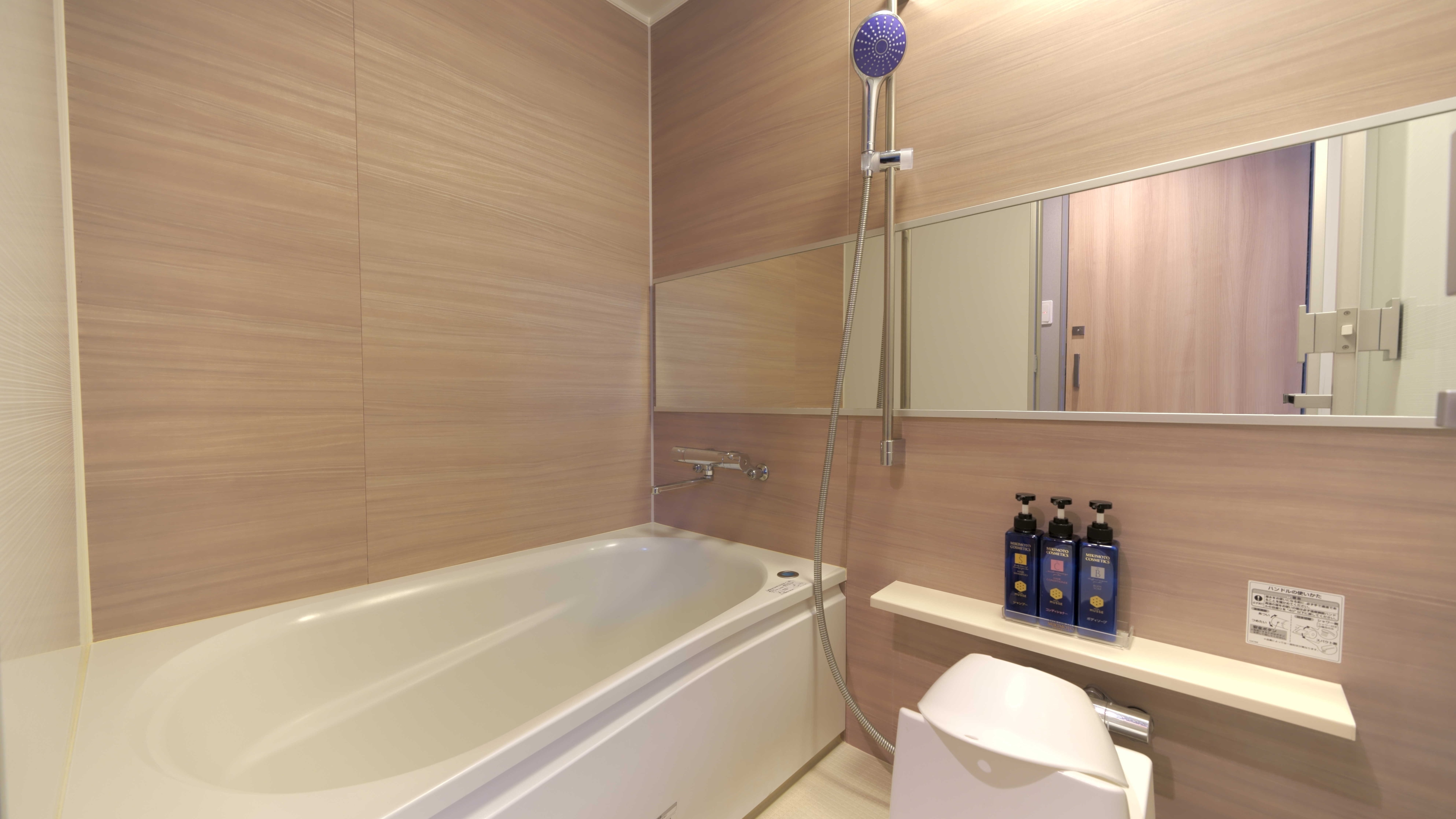 A bathroom in a regular guest room (1216 size). Equipped with bathtub, shower and washing area.