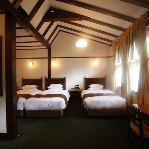 [Guest Room/Superior Triple] A room with an open ceiling and soft light.