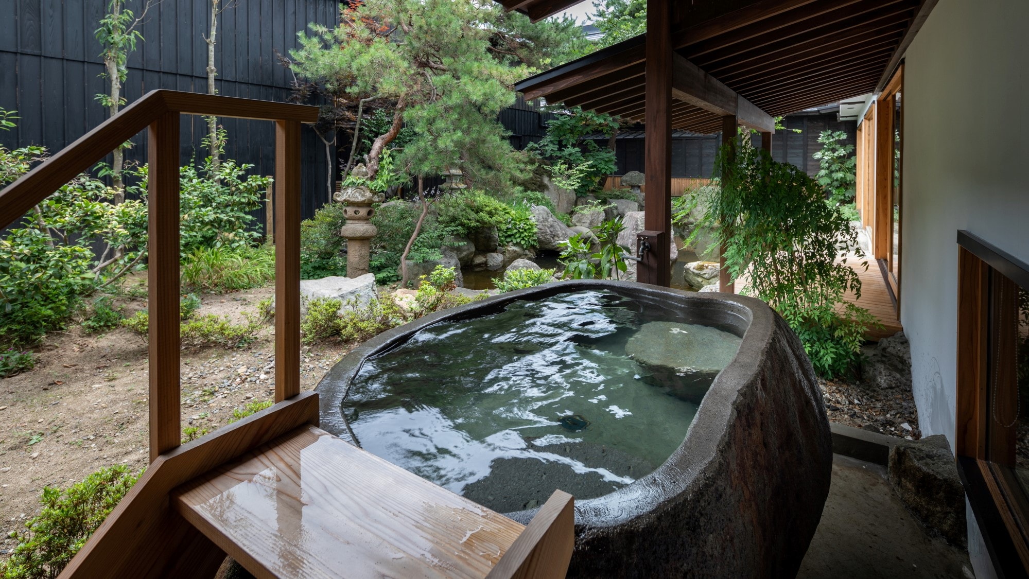 [KURA01] A guest room with an open-air bath that is hollowed out from a megalith of Zao stone facing the garden.