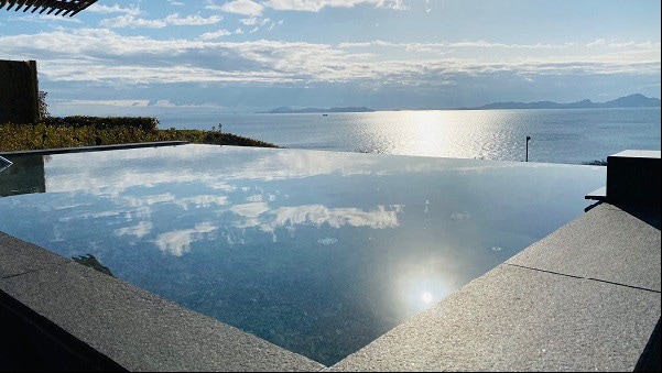 The open-air bath (women's bath) stands out against the clear blue sky