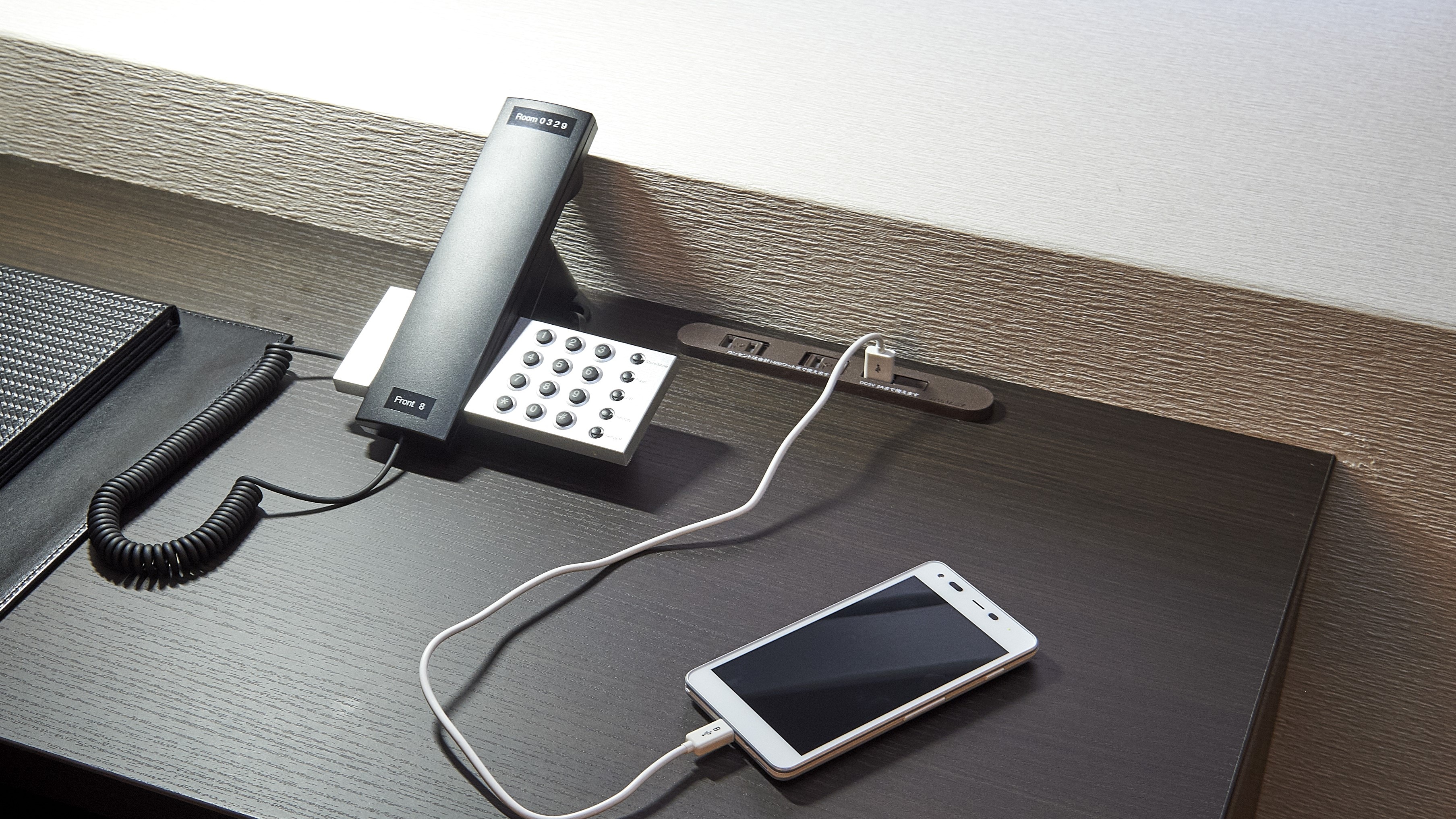 USB port, AC outlet and internal phone on the desk (example in guest room)