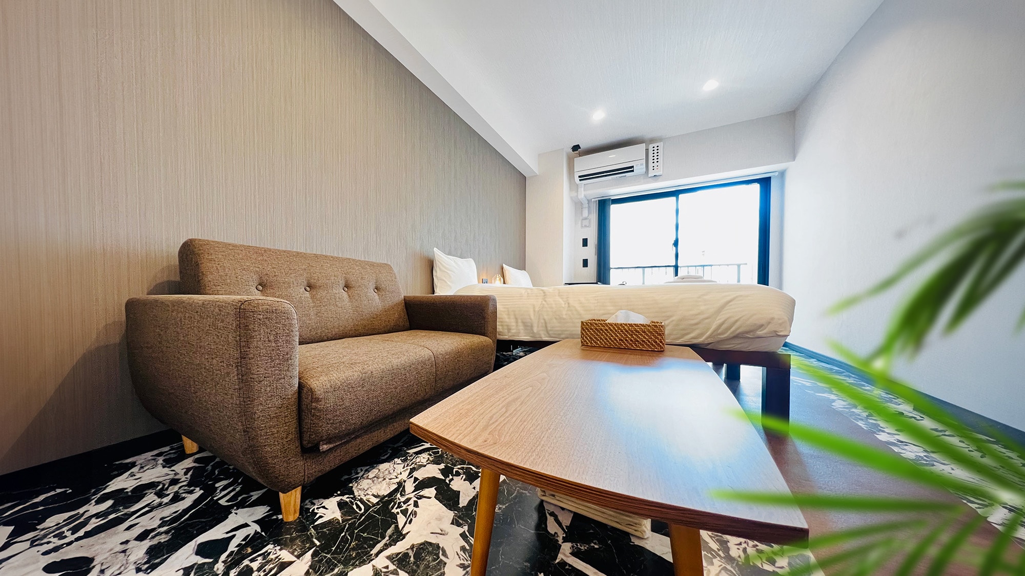 Twin room with sofa and table, providing a relaxing space to dine.