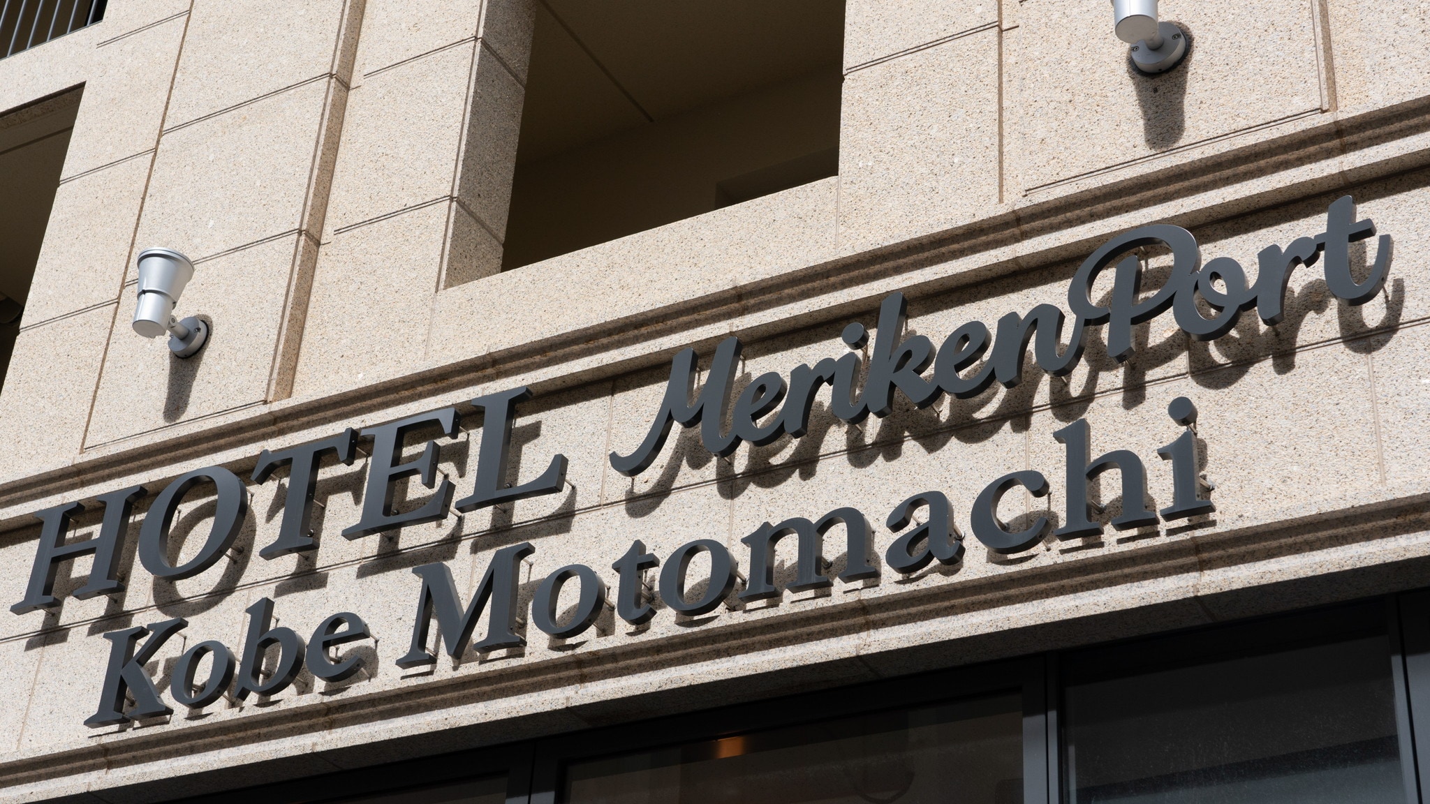 Papan nama hotel dirancang dengan penuh gaya agar sesuai dengan eksterior.